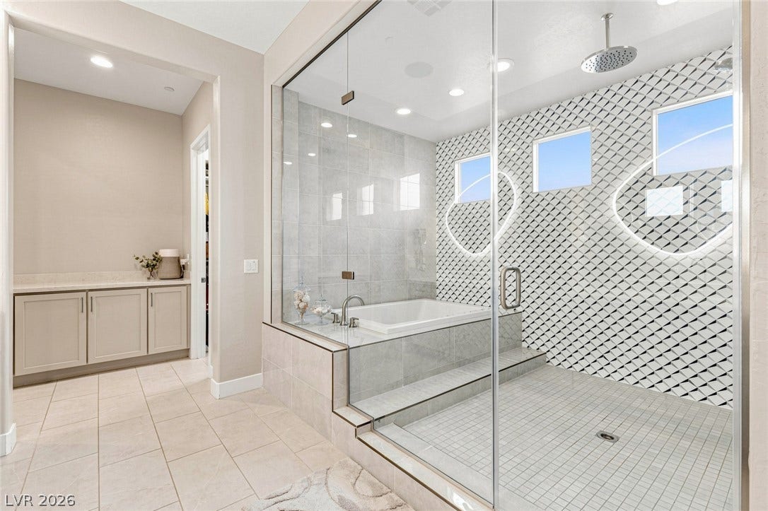 An integrated soaking tub and walk-in shower showcase modern tile work and glass walls.