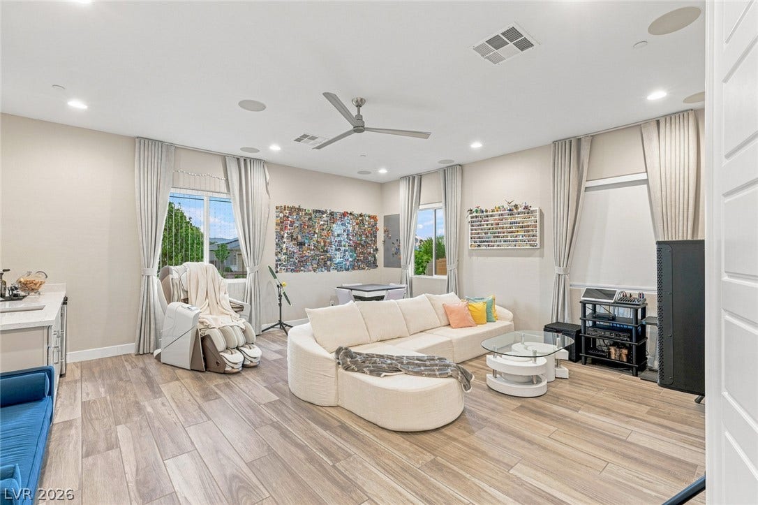 Smooth wood-look tile floors and recessed lighting enhance this versatile living space.