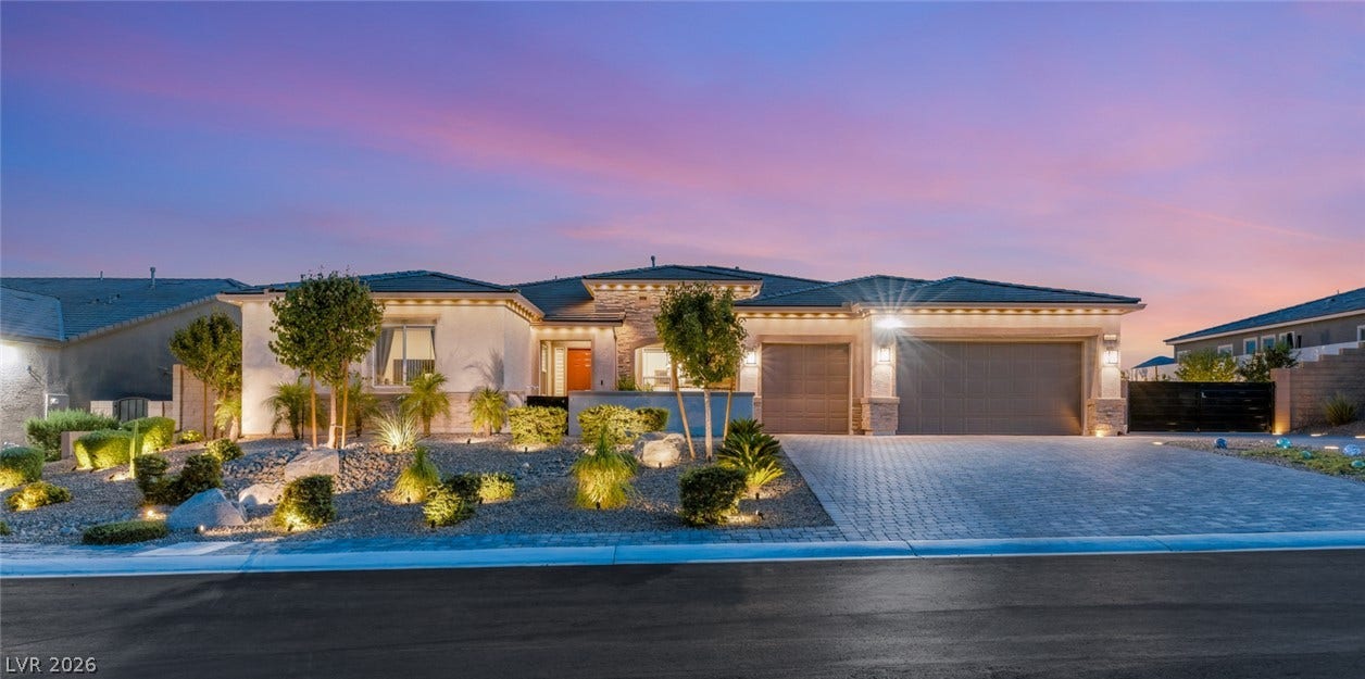 Dramatic sunset skies frame a modern exterior with stone accents and manicured desert landscaping.