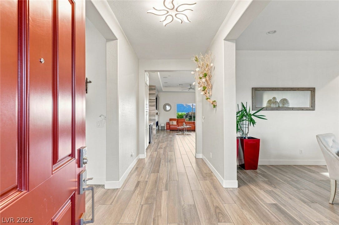 Gleaming wood-look tile floors guide guests into a bright, open-concept main level foyer.