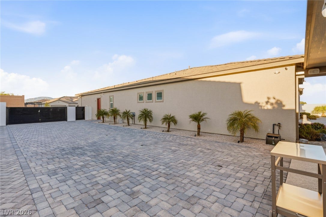 A spacious paved motor court wraps around the side of this modern stucco home.
