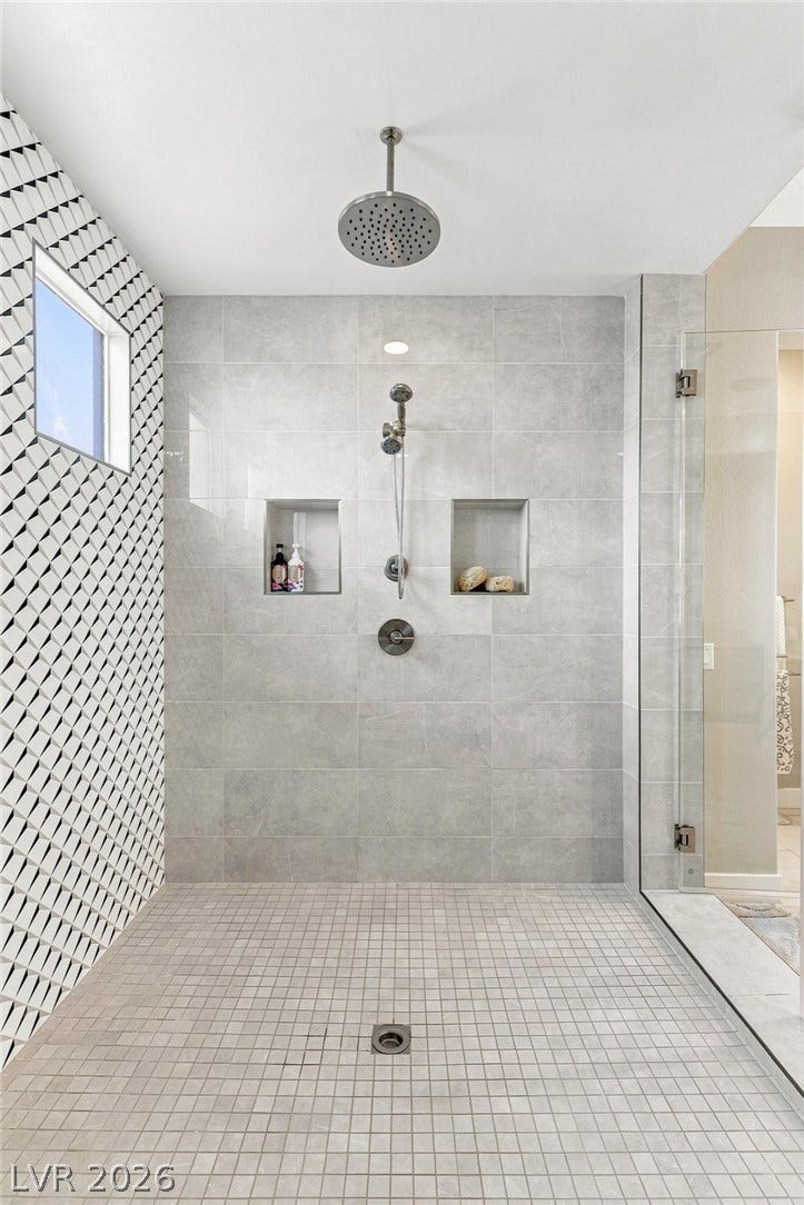 Geometric accent tile and a dual shower head system elevate this modern walk-in shower.