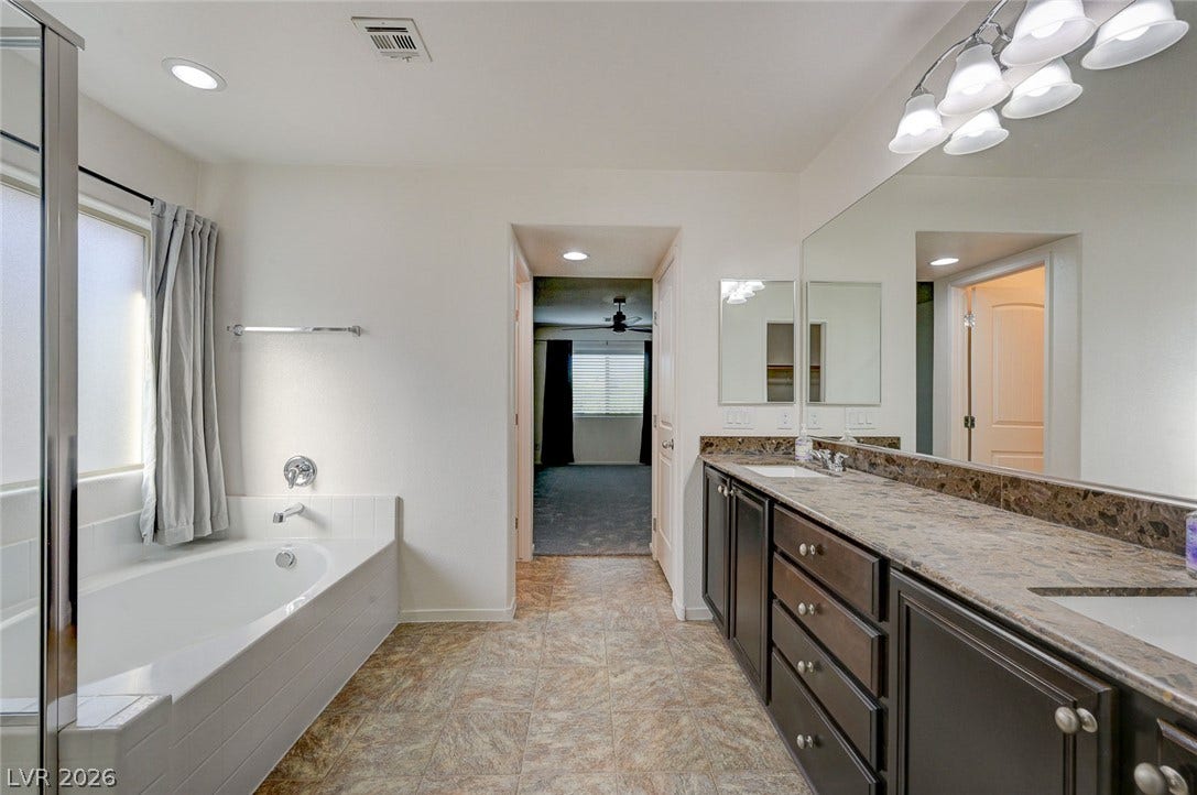 5608 Beckett Hill Court, Las Vegas, NV 89135 An expansive double vanity and a built-in soaking tub define this well-appointed private bath.