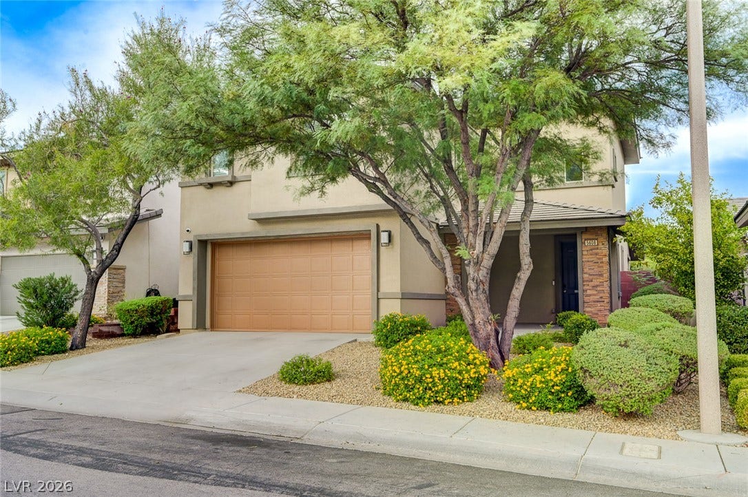 5608 Beckett Hill Court, Las Vegas, NV 89135 Lush desert landscaping frames the front elevation of this two-story stucco residence with attached garage.