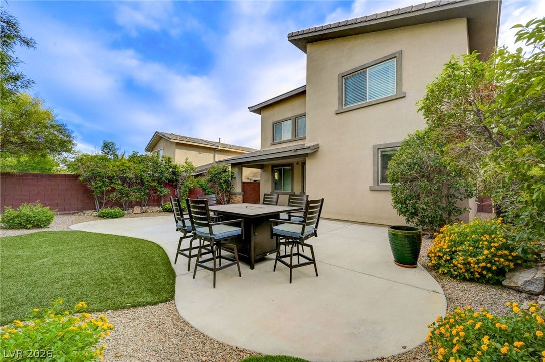 5608 Beckett Hill Court, Las Vegas, NV 89135 An open concrete patio offers an inviting outdoor space adjacent to the grassy yard.