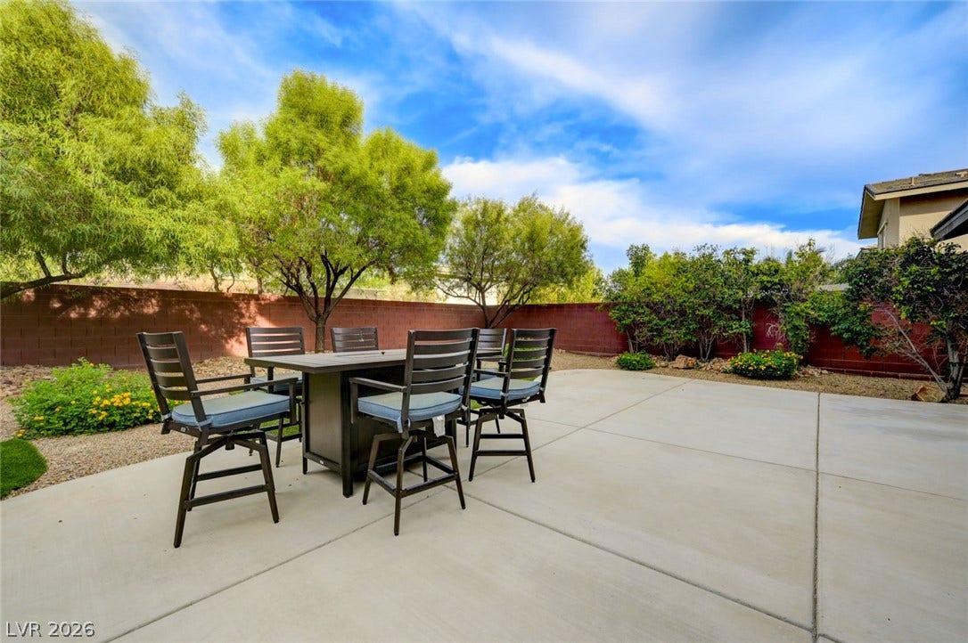 5608 Beckett Hill Court, Las Vegas, NV 89135 An expansive concrete patio anchors the private backyard framed by established trees and block fencing.