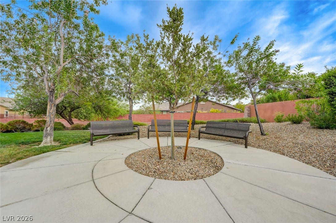 5608 Beckett Hill Court, Las Vegas, NV 89135 Mature trees shade a circular concrete seating area bordered by gravel and lawn.