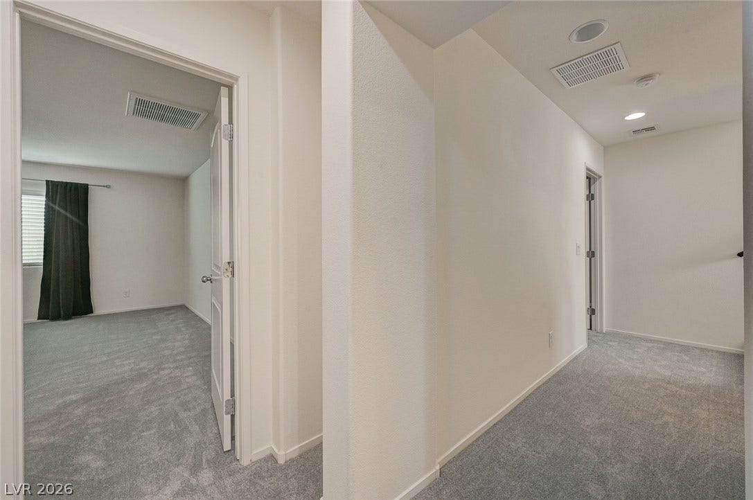 5608 Beckett Hill Court, Las Vegas, NV 89135 A well-lit hallway with neutral carpet leads to adjacent private quarters.