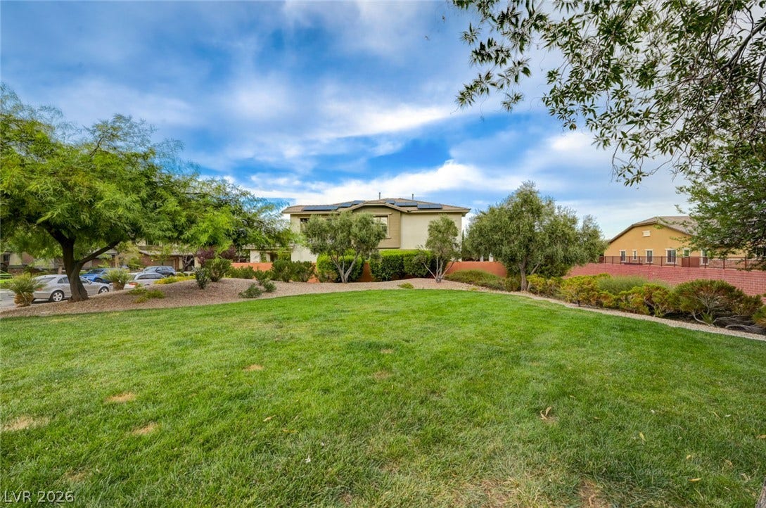 5608 Beckett Hill Court, Las Vegas, NV 89135 Mature trees frame a wide expanse of green lawn beneath a blue sky.