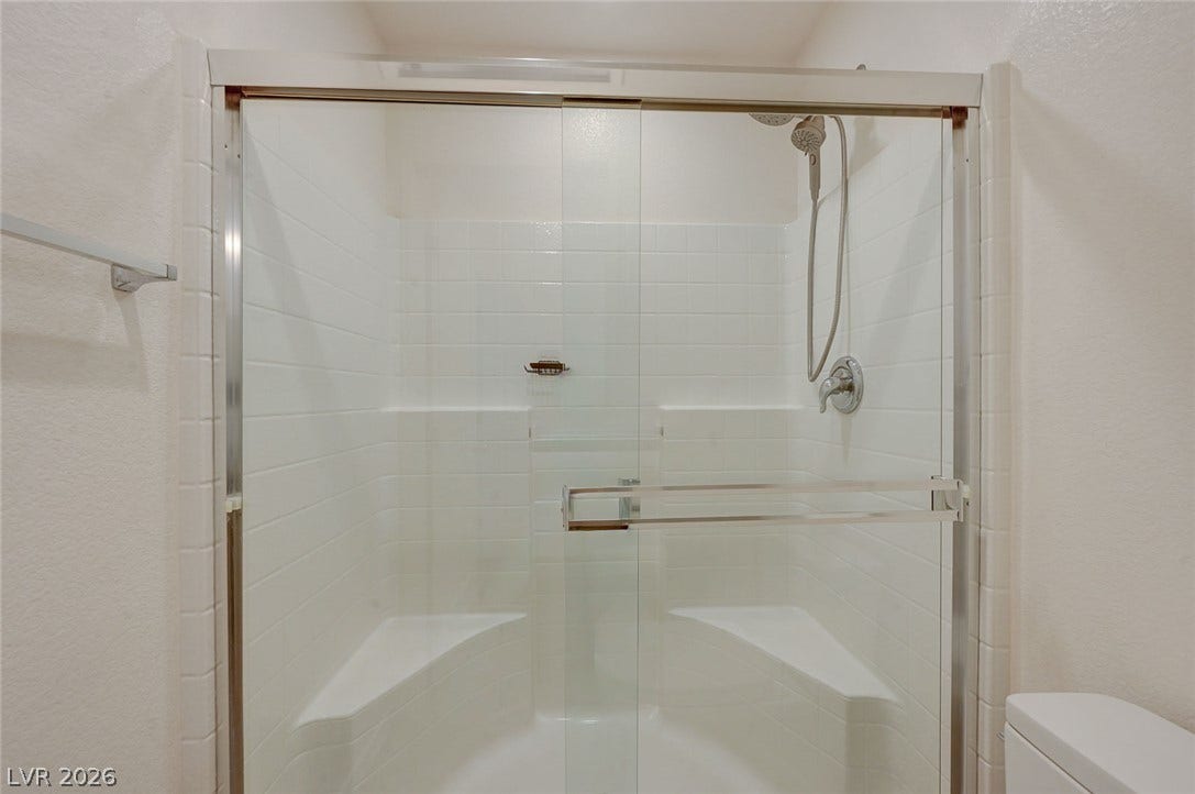 5608 Beckett Hill Court, Las Vegas, NV 89135 A glass-enclosed shower features classic subway tiling and built-in bench seating.