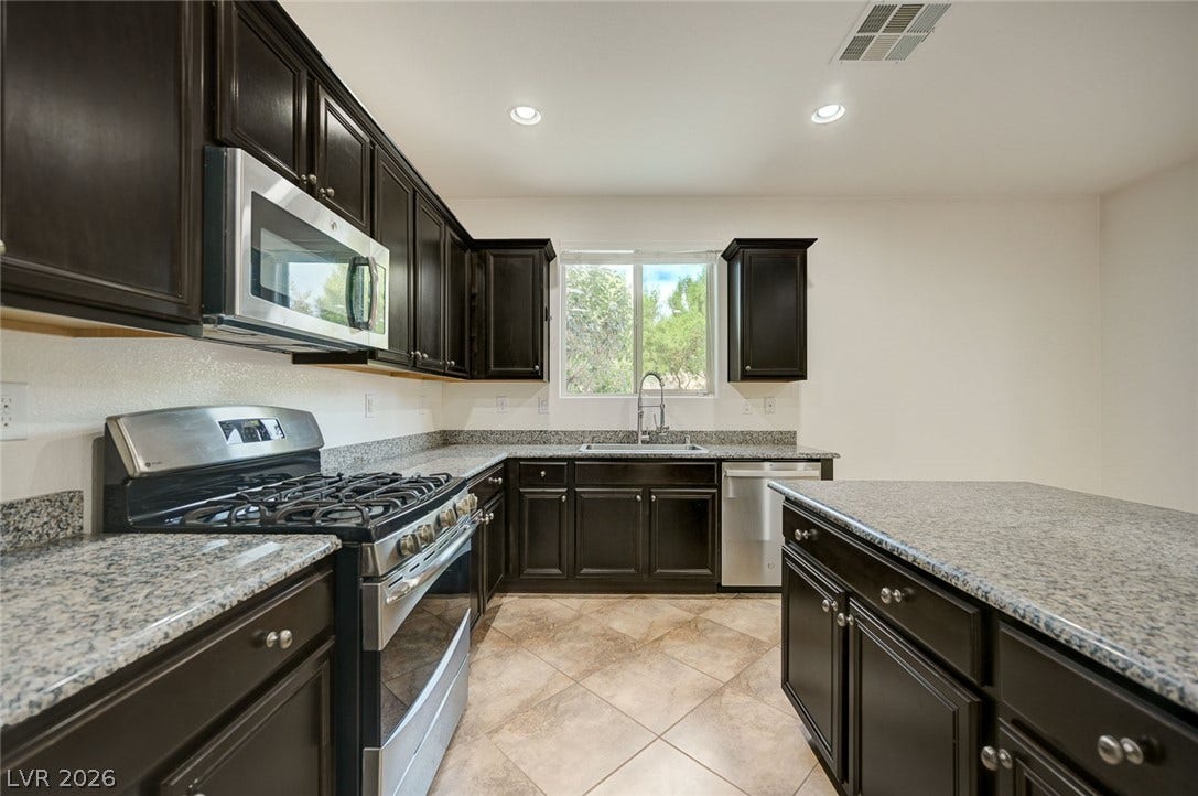 5608 Beckett Hill Court, Las Vegas, NV 89135 Rich dark cabinetry pairs beautifully with stone countertops and sleek stainless steel appliances.