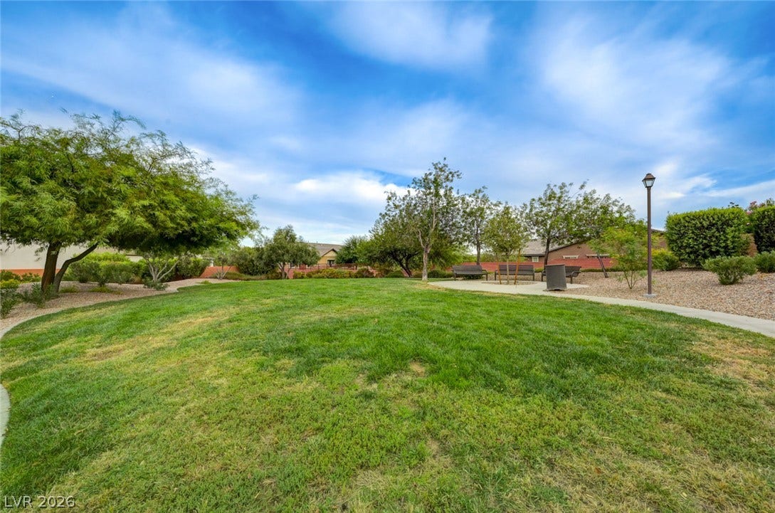 5608 Beckett Hill Court, Las Vegas, NV 89135 A winding concrete pathway borders a manicured green lawn framed by mature trees.