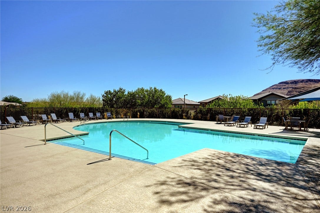5608 Beckett Hill Court, Las Vegas, NV 89135 A spacious concrete deck surrounds the refreshing community pool under a clear blue sky.