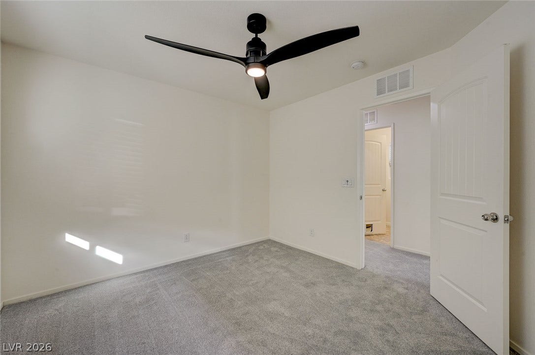 5608 Beckett Hill Court, Las Vegas, NV 89135 Plush wall-to-wall carpeting and clean neutral walls anchor this serene, versatile bedroom space.