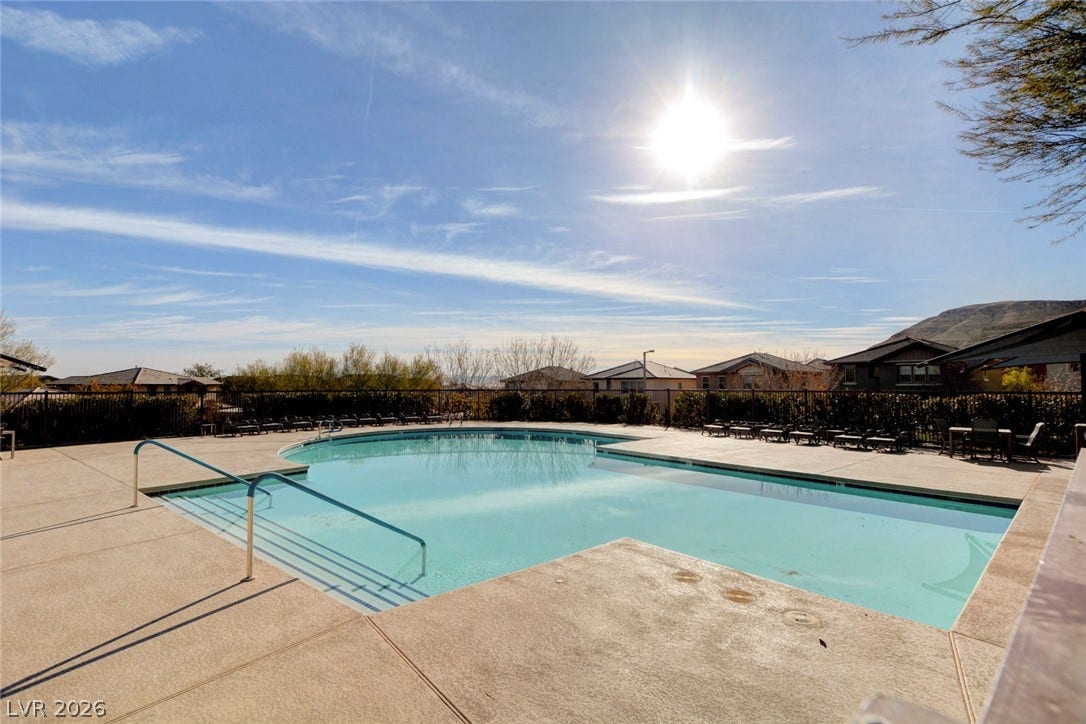5608 Beckett Hill Court, Las Vegas, NV 89135 A spacious concrete deck surrounds the refreshing community pool under a clear sunny sky.
