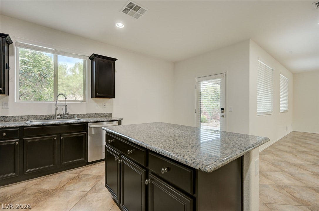 5608 Beckett Hill Court, Las Vegas, NV 89135 Polished stone countertops pair elegantly with dark cabinetry and tile flooring.