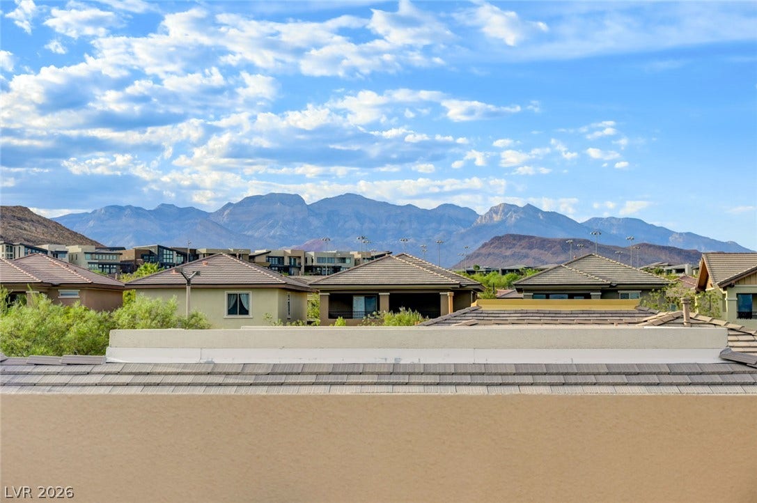 5608 Beckett Hill Court, Las Vegas, NV 89135 Dramatic mountain peaks frame the horizon beyond a quiet desert neighborhood.