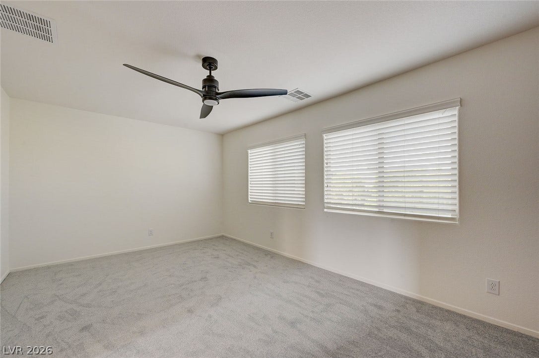 5608 Beckett Hill Court, Las Vegas, NV 89135 Soft carpet and dual windows with blinds anchor this versatile bedroom space.