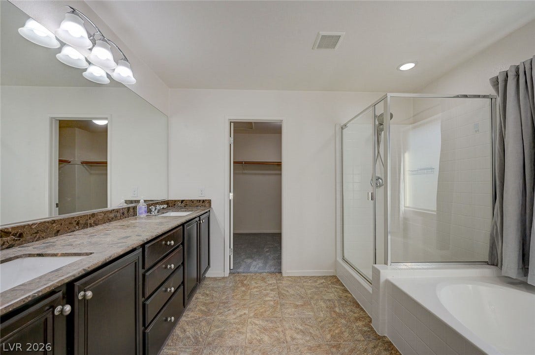 5608 Beckett Hill Court, Las Vegas, NV 89135 Double vanity sinks and stone counters complement a separate soaking tub and shower enclosure.