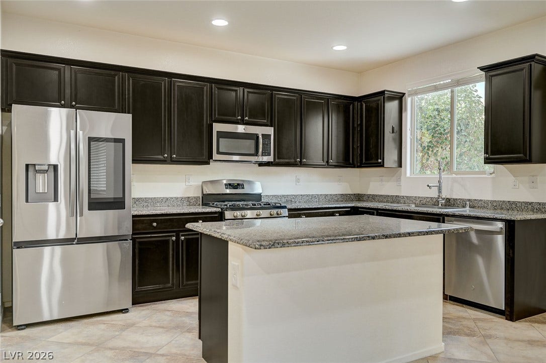 5608 Beckett Hill Court, Las Vegas, NV 89135 Dark cabinetry pairs beautifully with stone countertops and stainless steel appliances.