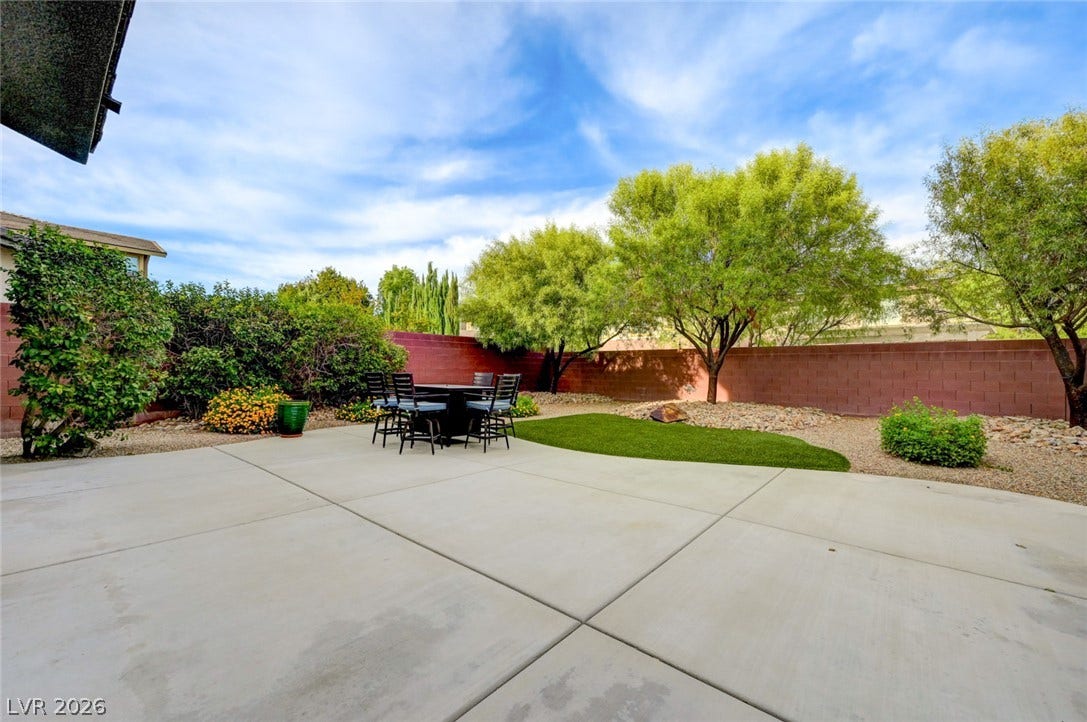 5608 Beckett Hill Court, Las Vegas, NV 89135 An expansive concrete patio overlooks the private, fenced yard surrounded by mature trees.
