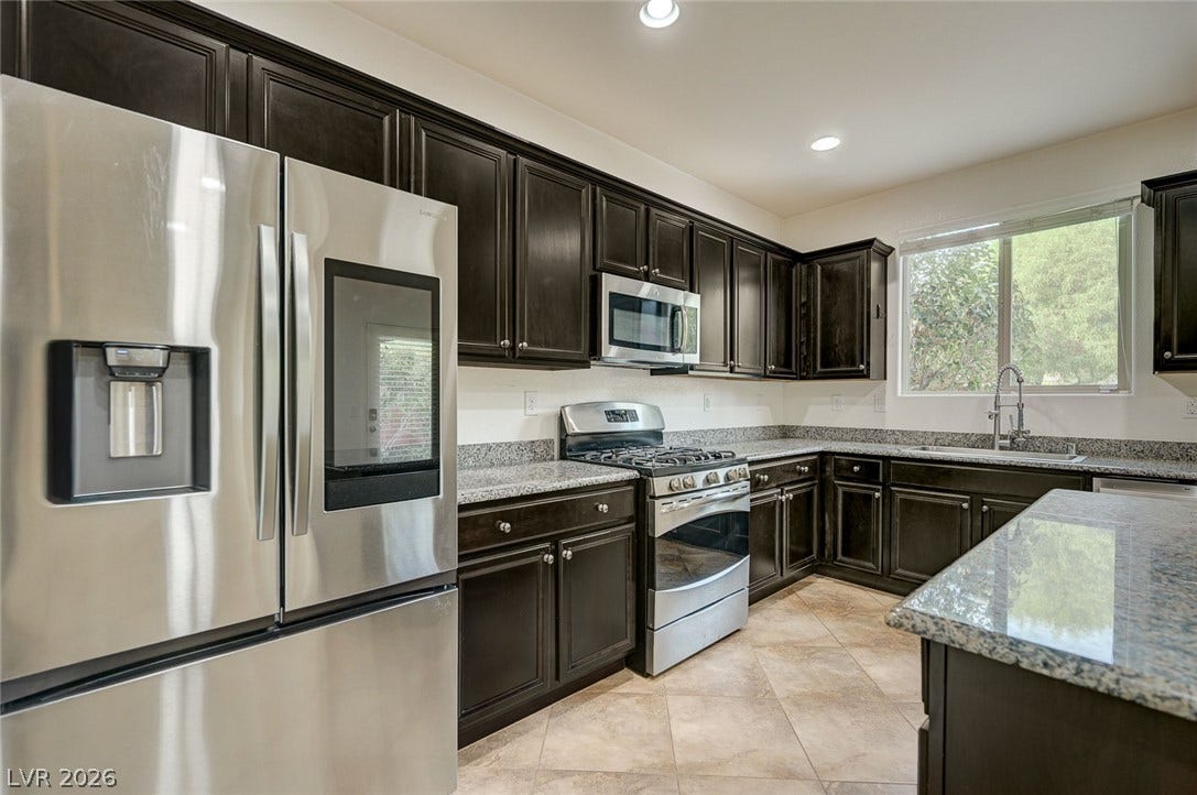 5608 Beckett Hill Court, Las Vegas, NV 89135 Rich dark cabinetry pairs beautifully with stone countertops and stainless steel appliances.