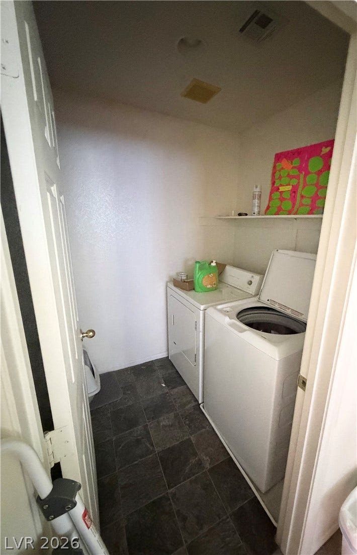 6408 Yucca Ridge Court, North Las Vegas, NV 89084 Tiled flooring pairs with overhead shelving in this functional laundry room.