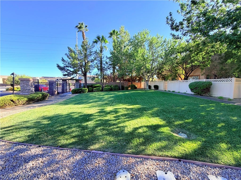 6408 Yucca Ridge Court, North Las Vegas, NV 89084 Mature trees and a manicured lawn create a serene setting within the gated perimeter.