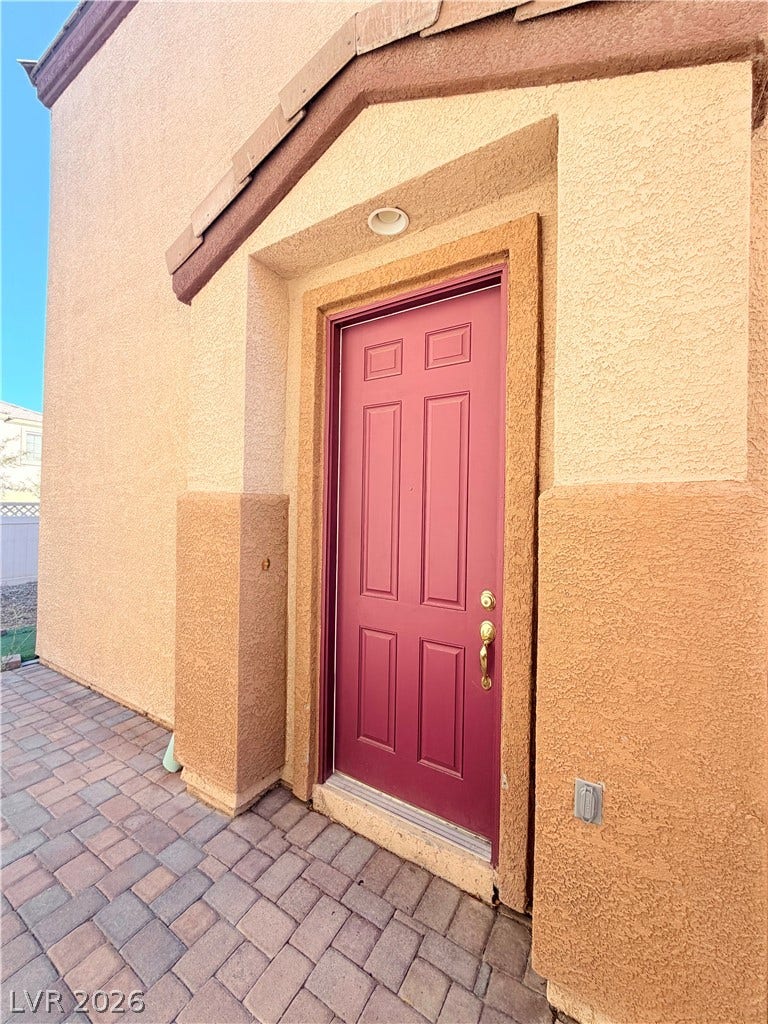 6408 Yucca Ridge Court, North Las Vegas, NV 89084 An inviting stucco entryway features a classic recessed door framed by durable paver tiles.