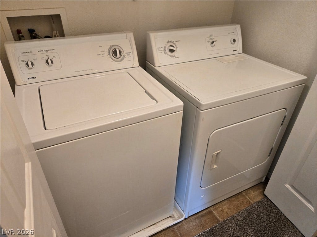 5935 Nuevo Leon Street, #2, North Las Vegas, NV 89031 Functional laundry setup highlights classic tile flooring and practical built-in wall utility connections.