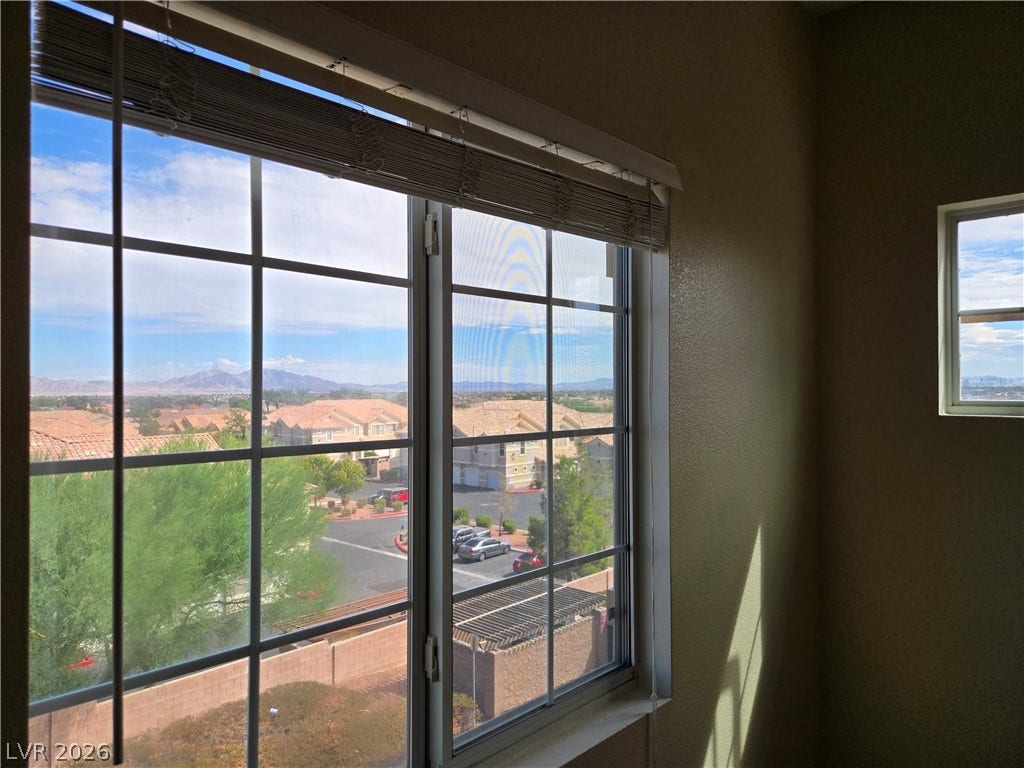 5935 Nuevo Leon Street, #2, North Las Vegas, NV 89031 Grid windows look out over the surrounding neighborhood toward distant mountain peaks.