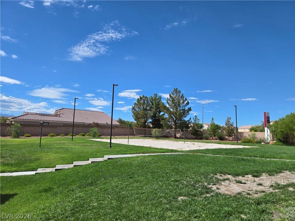 5935 Nuevo Leon Street, #2, North Las Vegas, NV 89031 Lush grassy grounds frame a sand volleyball court under blue desert skies.