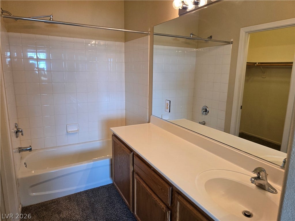 5935 Nuevo Leon Street, #2, North Las Vegas, NV 89031 Tiled tub surround and a large vanity mirror enhance this functional bathroom layout.