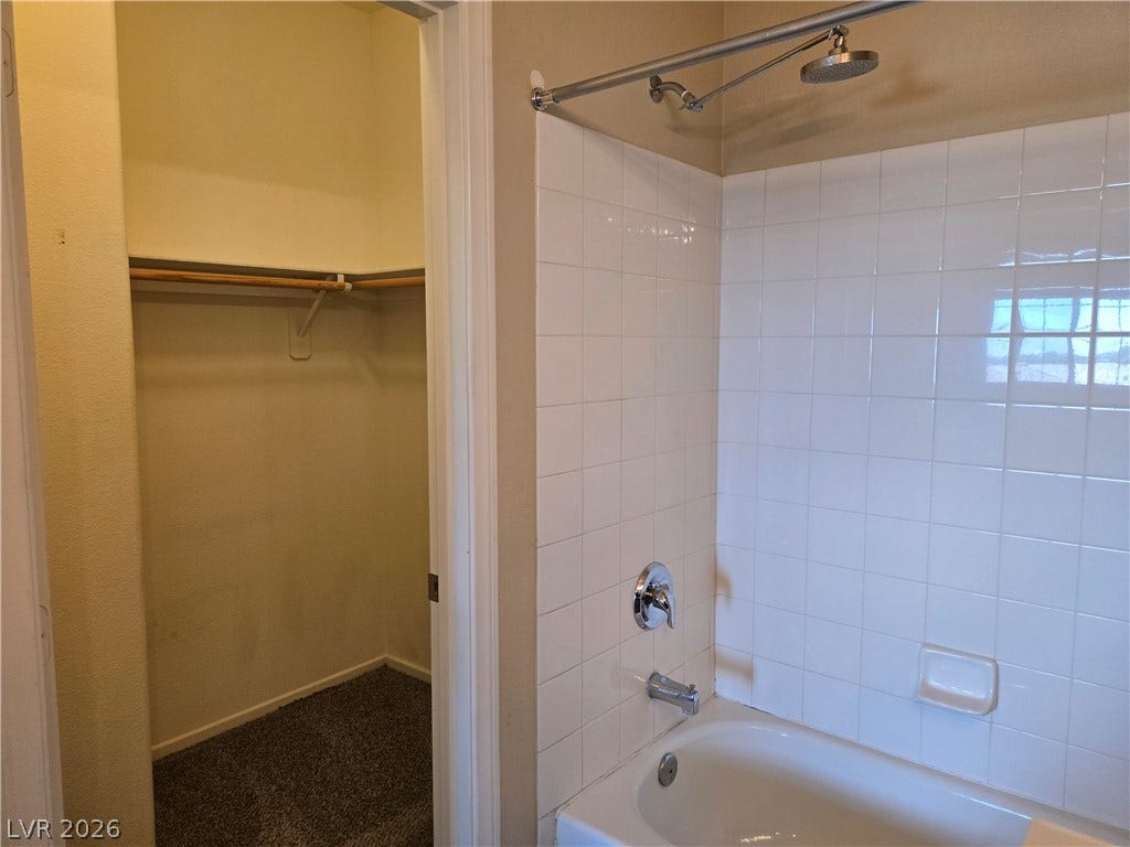5935 Nuevo Leon Street, #2, North Las Vegas, NV 89031 Tiled shower surround matches the clean design next to a nearby walk-in closet.