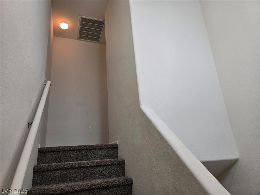 5935 Nuevo Leon Street, #2, North Las Vegas, NV 89031 Carpeted stairs ascend alongside clean walls and a simple handrail.