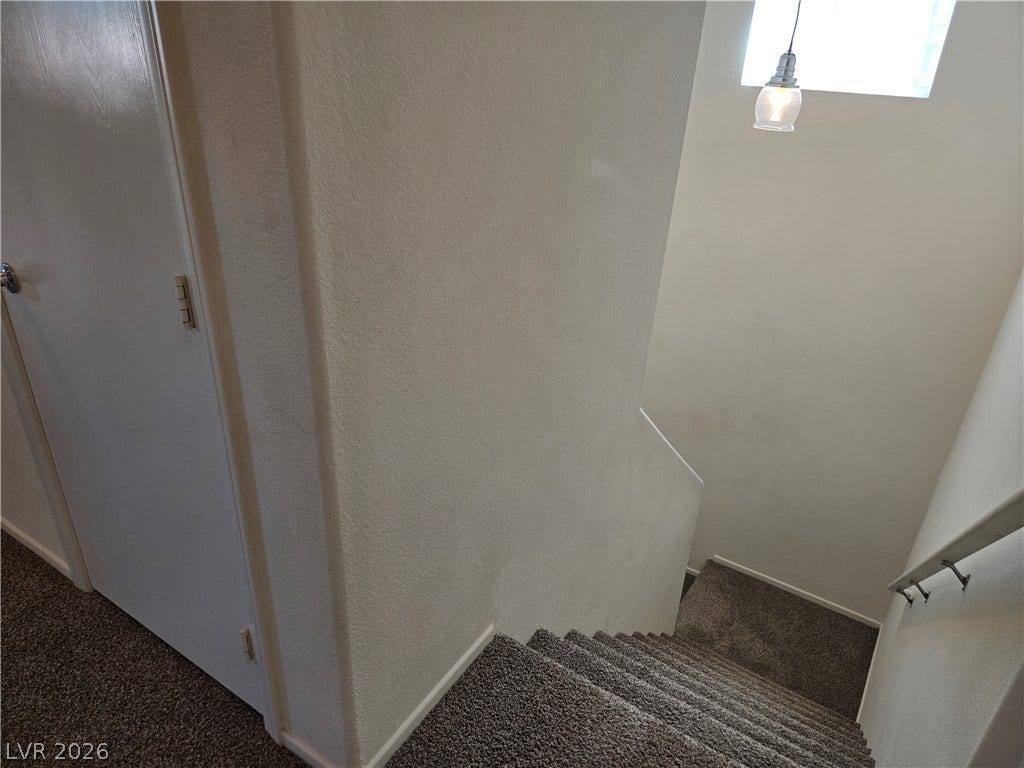 5935 Nuevo Leon Street, #2, North Las Vegas, NV 89031 A carpeted staircase descends past neutral walls lit by a high window.
