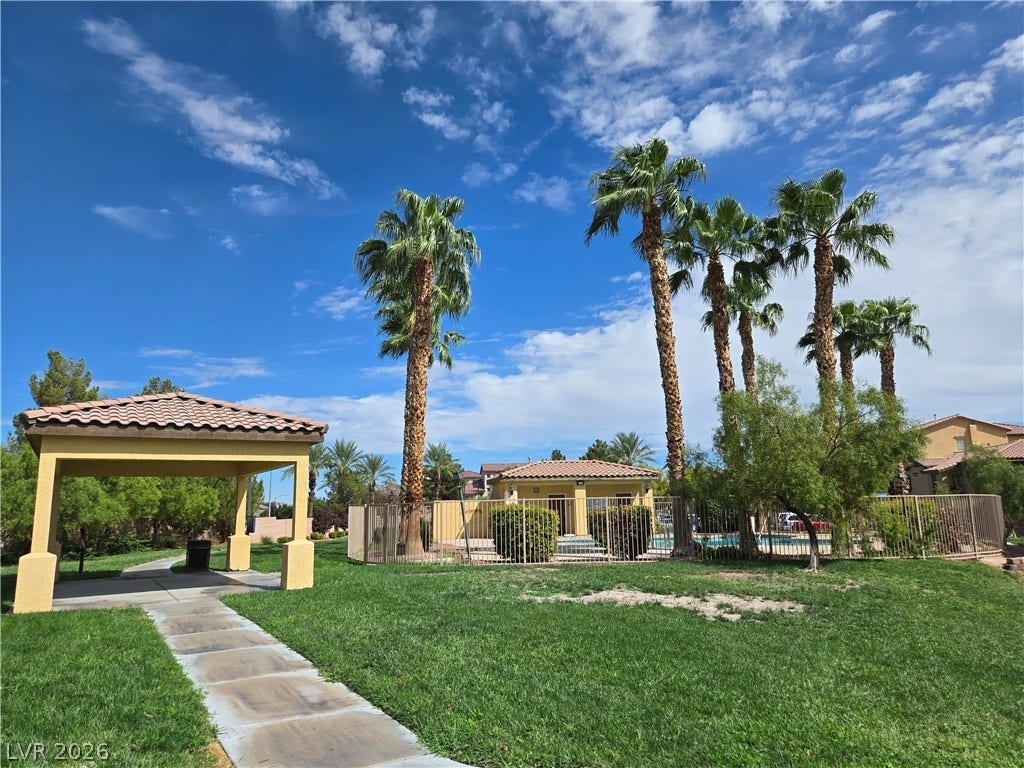 5935 Nuevo Leon Street, #2, North Las Vegas, NV 89031 A paved path leads past a covered pavilion toward a fenced-in community pool area.