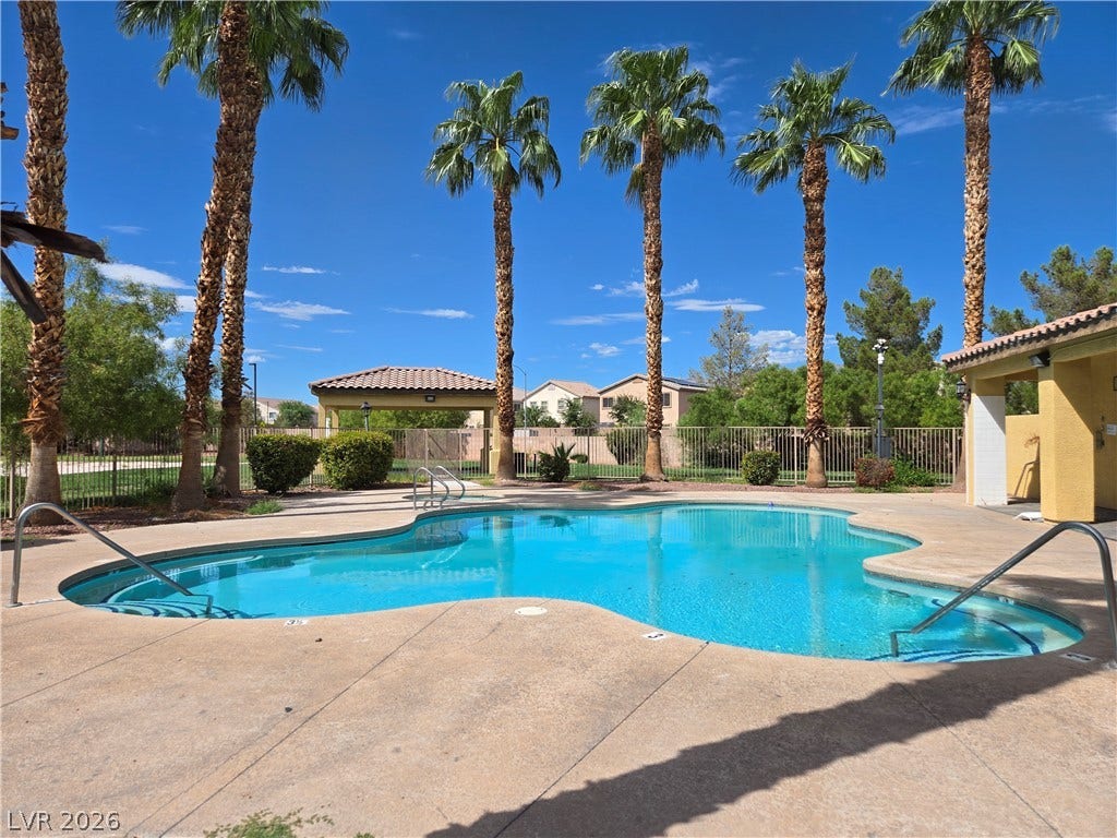 5935 Nuevo Leon Street, #2, North Las Vegas, NV 89031 Towering palm trees frame a sparkling community pool lined by a spacious concrete deck.