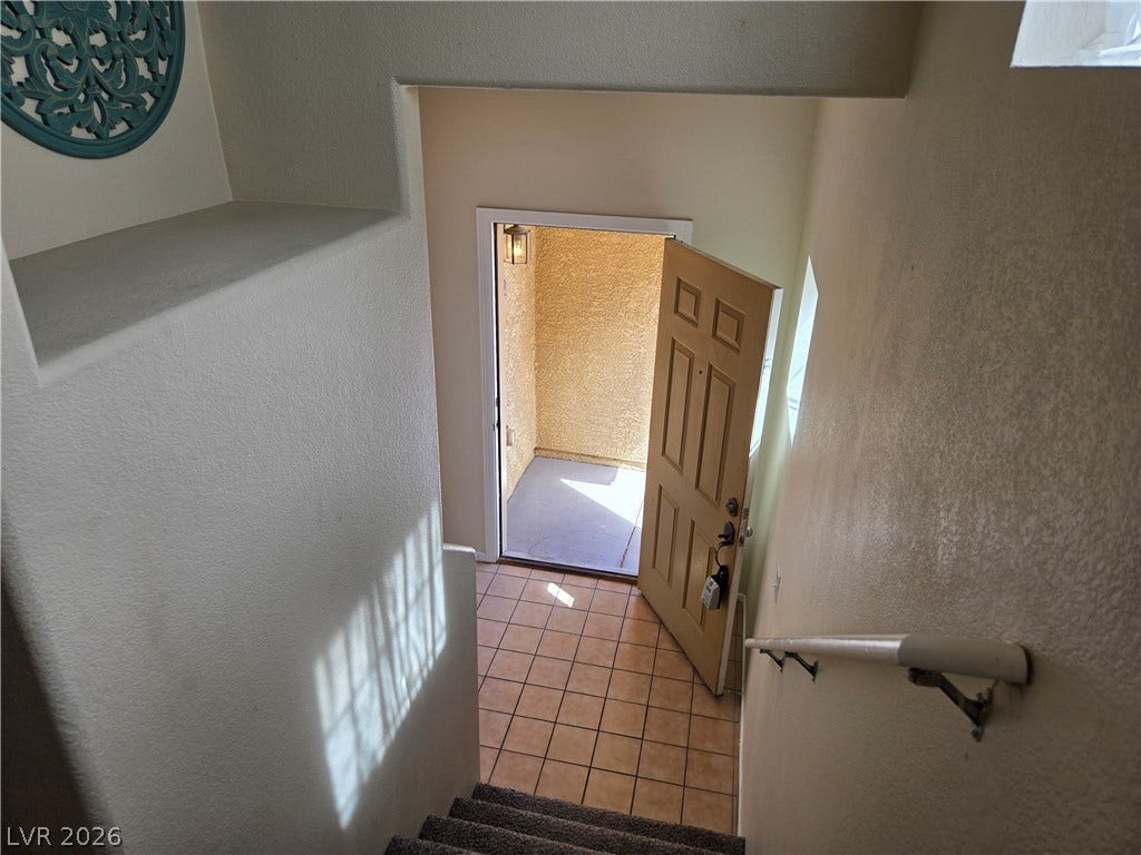 5935 Nuevo Leon Street, #2, North Las Vegas, NV 89031 Natural light streams down the carpeted stairs into a tiled entryway with a private entrance.
