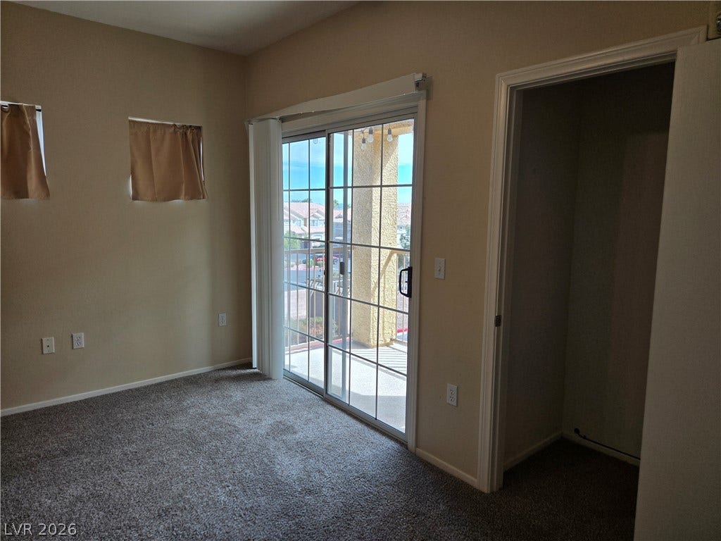 5935 Nuevo Leon Street, #2, North Las Vegas, NV 89031 Sliding glass doors open directly to a private balcony from this carpeted bedroom.