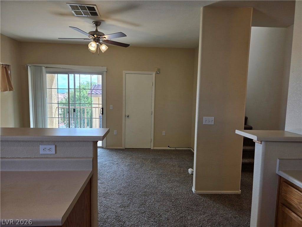 5935 Nuevo Leon Street, #2, North Las Vegas, NV 89031 Sliding glass doors open to a private balcony from this carpeted living area.