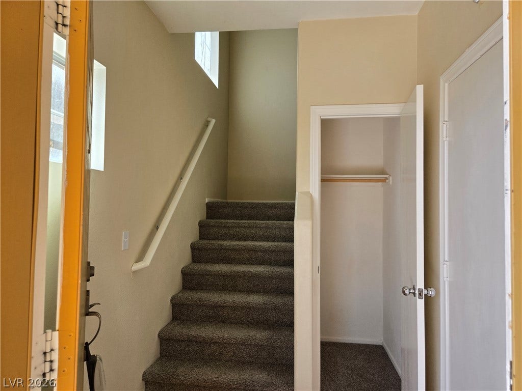 5935 Nuevo Leon Street, #2, North Las Vegas, NV 89031 Carpeted stairs ascend next to a convenient entryway closet in this welcoming home foyer.