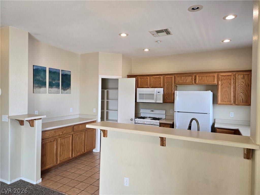 5935 Nuevo Leon Street, #2, North Las Vegas, NV 89031 Rich wood cabinetry and tile flooring define this functional kitchen layout.