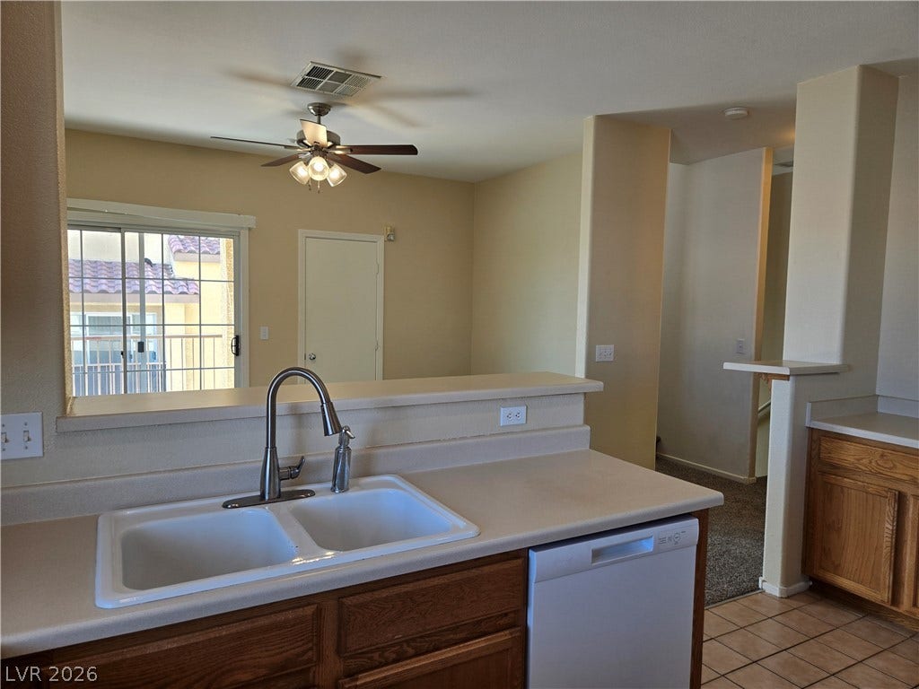 5935 Nuevo Leon Street, #2, North Las Vegas, NV 89031 An open pass-through looks from the kitchen into the dining area and sliding glass doors.
