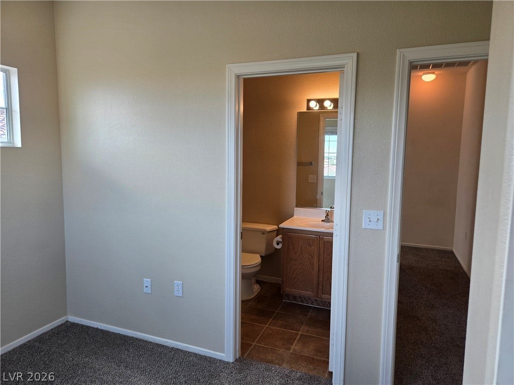 5935 Nuevo Leon Street, #2, North Las Vegas, NV 89031 A view from the carpeted room leads directly into an adjacent tile-floored bathroom.