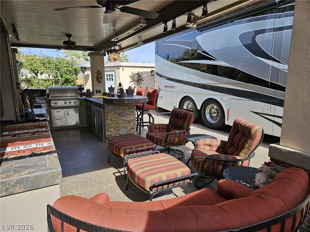 8175 Arville Street, #287, Las Vegas, NV 89139 A spacious covered patio features a built-in stone kitchen alongside a convenient concrete driveway area.