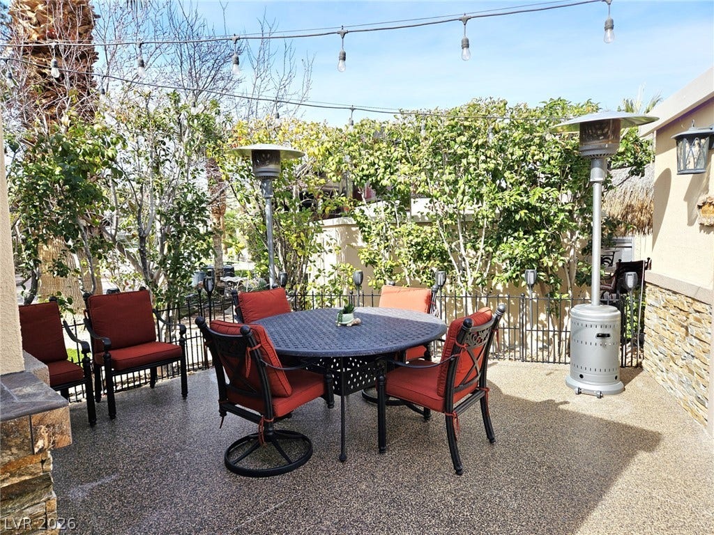 8175 Arville Street, #287, Las Vegas, NV 89139 An inviting outdoor patio features textured flooring and stone-accented walls framed by lush greenery.