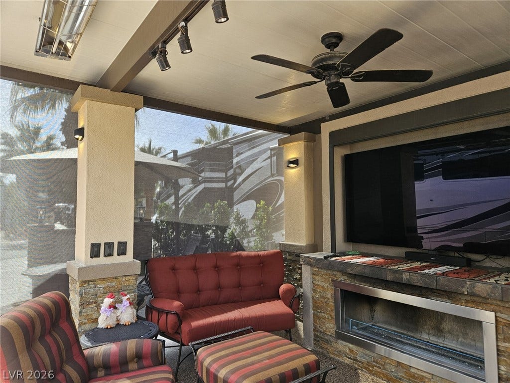 8175 Arville Street, #287, Las Vegas, NV 89139 A stone-accented fireplace anchors this covered patio designed for seamless indoor-outdoor living.