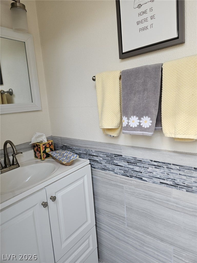 8175 Arville Street, #287, Las Vegas, NV 89139 Tiled wainscoting and a classic white vanity bring clean style to this bathroom.