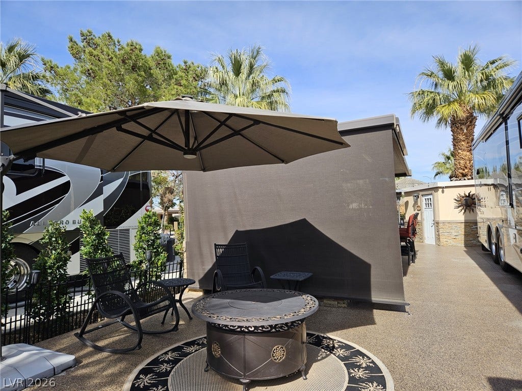 8175 Arville Street, #287, Las Vegas, NV 89139 A spacious concrete patio area features a fire pit and palm tree views.